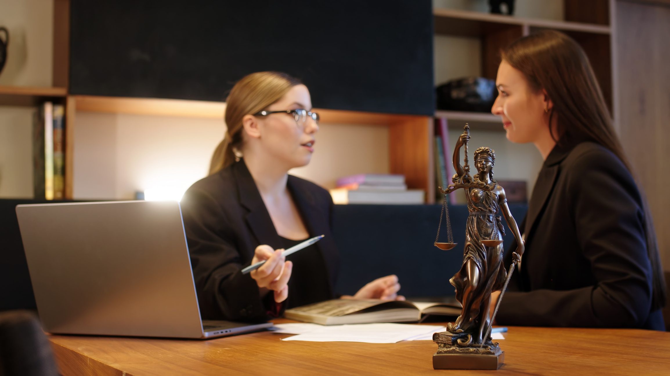 Two women engaged in a serious discussion at a desk.