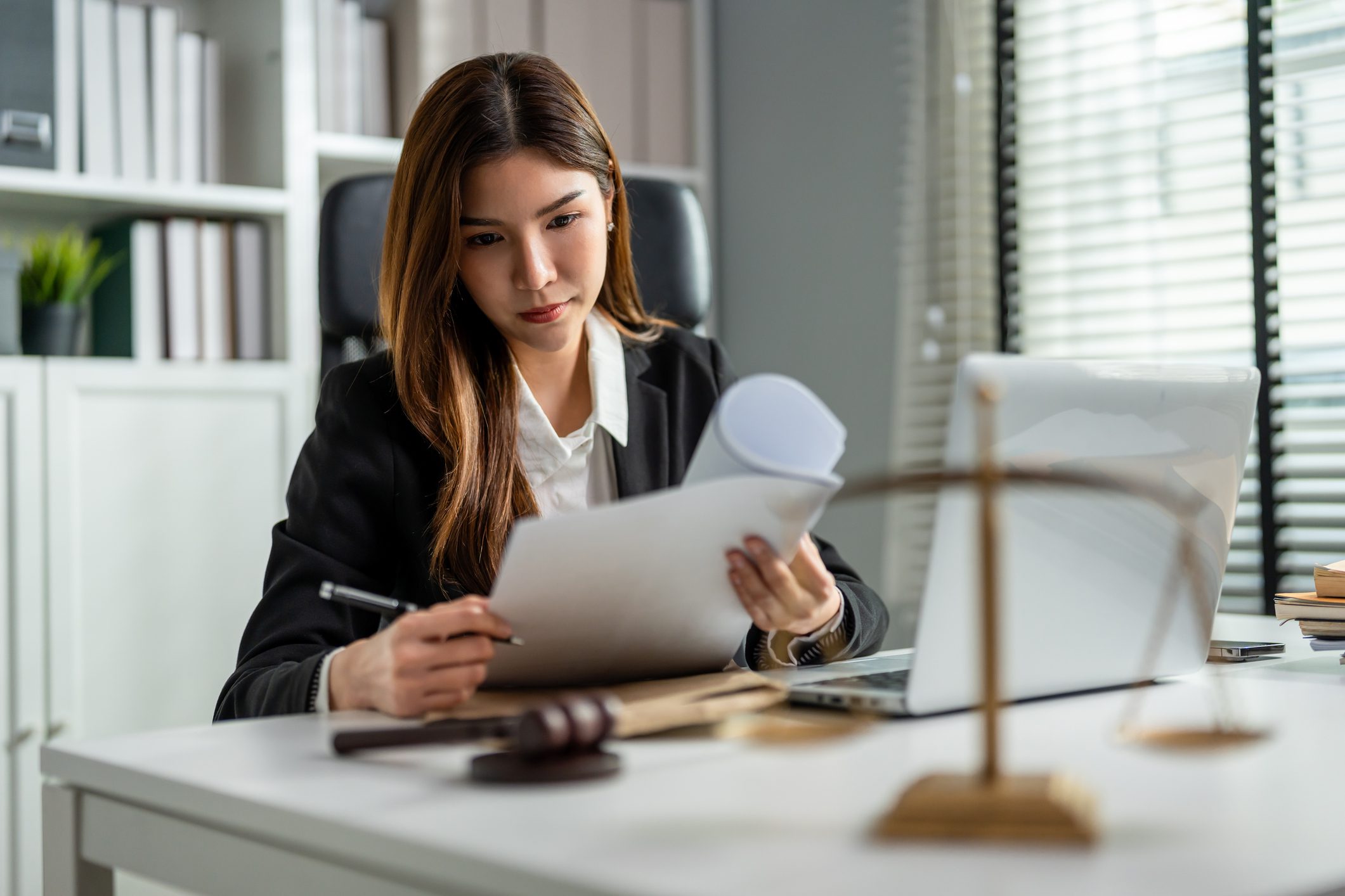 Woman reviewing legal documents at her desk.