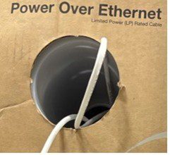 White cables passing through a circular hole in a cardboard box labeled Power Over Ethernet.