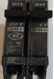 Close-up of two black 20A circuit breakers labeled OFF.