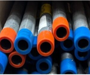 Close-up of blue and orange plastic pipes stacked together.