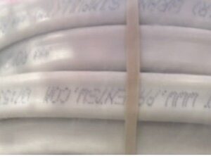Stacked white pipes with faint markings and a securing strap.