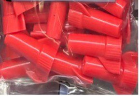 A pile of red plastic wire connectors in a clear plastic bag.