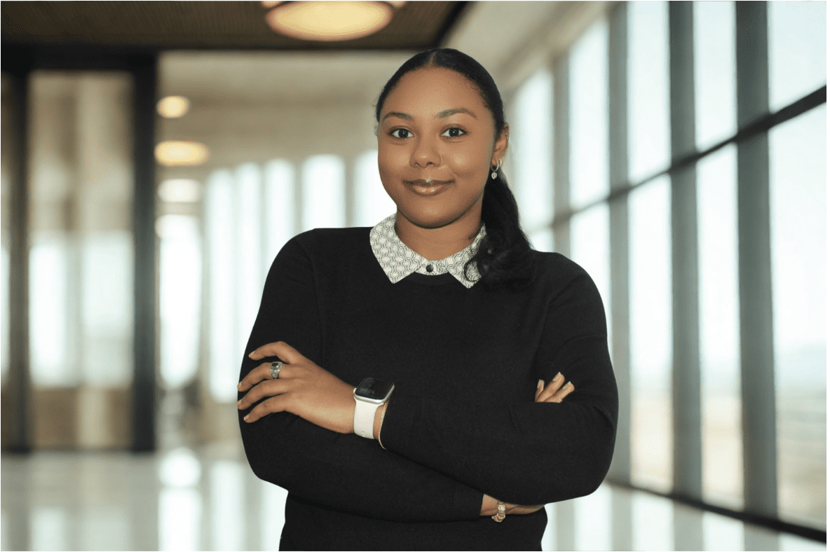 Professional woman standing confidently with arms crossed.